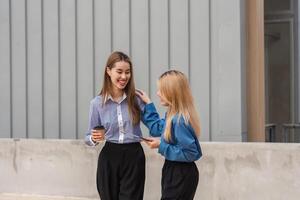 Diverse women walking together and discussing ideas while holding coffee. photo
