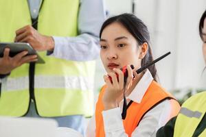 Construction supervisor communicating with team using a walkie-talkie during a project meeting photo