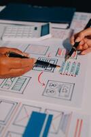 Two people working on a project with a pen and paper photo