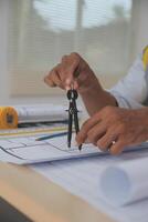 A person is holding a pair of scissors while working on a piece of paper photo
