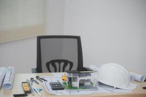 A desk with construction tools and a hard hat photo