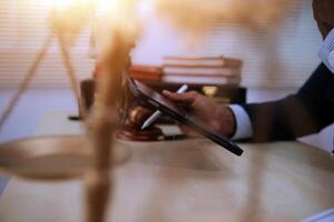 A man in a suit is using a tablet to write a document on a desk photo