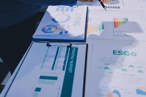 A person is looking at a table with papers and graphs photo