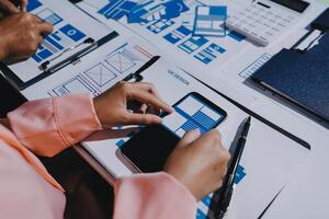 A person is using a smartphone on a table with other papers photo