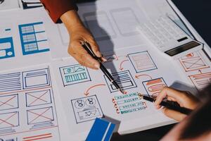 A person is working on a design project with a pen and paper photo