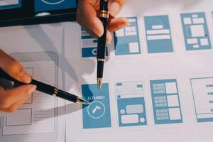 A person is using a pen to draw a design on a tablet photo