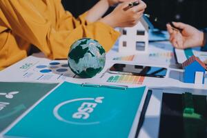 Business people working on a project with a house and a globe photo