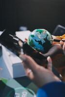 A person holding a globe and a phone photo