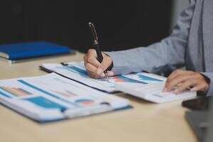 A person is writing on a piece of paper with a pen photo