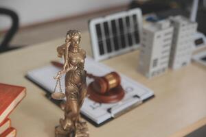 Lawyer statue on desk with books and law books photo