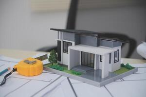 A model house on top of a table with a tape measure photo