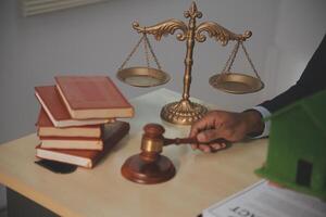 A man in a suit sits at a desk with a gavel and books photo