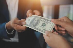 A man handing a dollar to another man photo