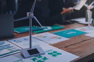 Wind turbine on table with papers and graphs photo