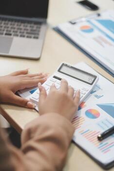 A person is using a calculator on a desk photo