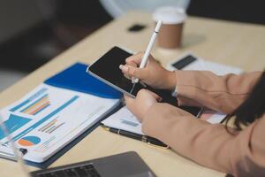 A woman is writing on a tablet while sitting at a desk photo