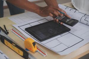 A man using a calculator to calculate the cost of a home renovation photo