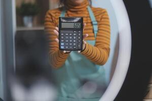 A woman holding a calculator in front of a mirror photo