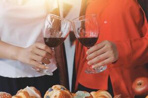 Two people toasting with wine glasses photo