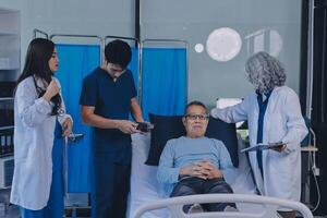 A group of doctors and nurses standing around a patient in a hospital room photo