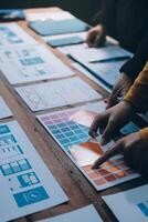 personas trabajando en un diseño proyecto en un mesa foto
