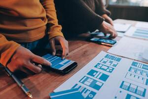 Two people are using a smartphone to look at a design photo