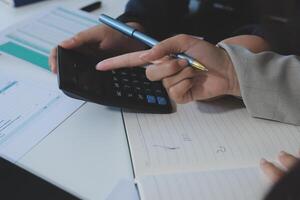 A person is using a calculator to write on a paper photo