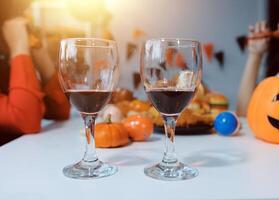 Two wine glasses with pumpkins on the table photo