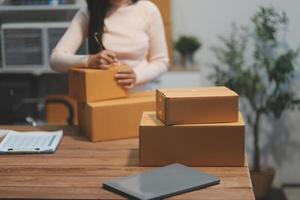 A woman is packing boxes on a desk photo