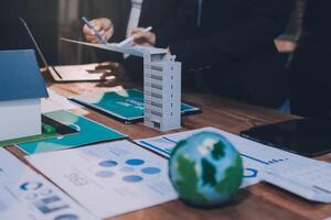Business people working on a project with a house and a globe photo