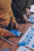A group of people working on blueprints on a table photo