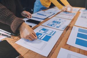 A group of people working on a project with blue and white papers photo