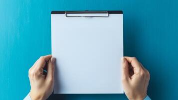 Interest Rates Retirement concept. Blank clipboard held by hands against a blue background. photo