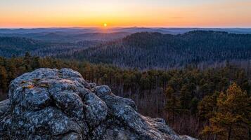 Burnout recovery mental concept. Vibrant sunset over a forest landscape from a rocky viewpoint. photo