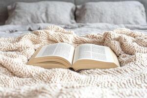 Burnout recovery mental concept. Open book on a cozy bed with soft blankets and pillows in the background. photo