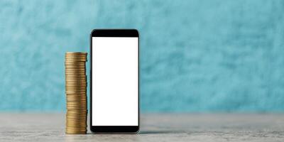 Inflation financial pressure concept. Smartphone beside a stack of coins on a textured background. photo
