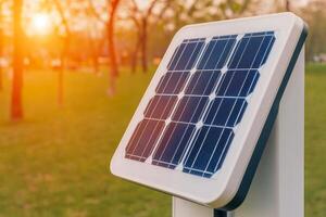 Future lifestyle sustainability connected concept. Solar panel capturing sunlight in a green park during sunset. photo
