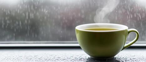 Burnout recovery stress concept. Warm cup of tea beside a rainy window. photo