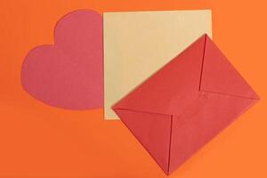 An envelope and a red heart shaped envelope photo
