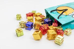 Top view of miniature gift boxes spilling from a festive green bag photo