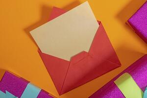Red envelope containing a letter placed on an orange background surrounded by gift boxes. photo
