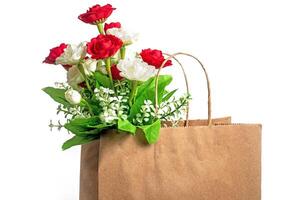 Beautiful red and white roses in a paper bag on a white background, Closeup photo