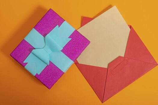 An open envelope with a colorful bow on top photo