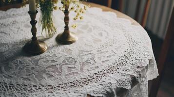 Lace tablecloth adorned with candles and flowers creates a cozy atmosphere in a rustic dining space photo