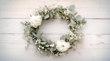 Elegant floral wreath adorned with white peonies and eucalyptus on a wooden surface photo