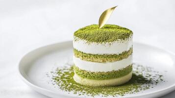 Delicate matcha cake with layers of cream and fine green tea powder presented on a white plate in a serene setting photo