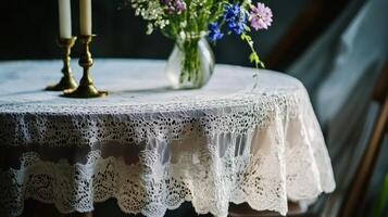 Elegant table setting with lace tablecloth and fresh flowers in a cozy indoor space during the afternoon photo