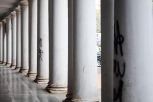 A row of white columns with graffiti on them photo