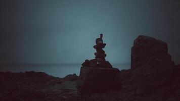 equilibrado piedras crear armonía en un rocoso playa a crepúsculo video