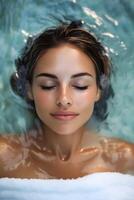 Relaxation and tranquility experienced by a young woman submerged in water with closed eyes in a serene spa environment photo